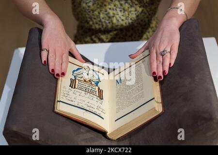 LONDRES, ROYAUME-UNI - 03 DÉCEMBRE 2021 : un membre du personnel ouvre le Savoy cocktail Book (1930), variante spéciale en édition limitée de la première édition, signée par Harry Craddock l'un des barmen les plus célèbres des 1920s et 1930s, Lors d'un appel photo présentant les highligs de la semaine classique à la maison de vente aux enchères Christie sur 03 décembre 2021 à Londres, en Angleterre. (Photo de Wiktor Szymanowicz/NurPhoto) Banque D'Images