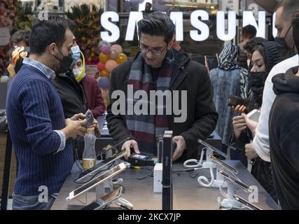 Un iranien regarde un pack d'iPhone 13 d'Apple tout en faisant du shopping dans une boutique DE plusieurs marques D'IT-City au centre informatique de Paytakht, dans le nord de Téhéran, sur 2 décembre 2021. Malgré les sanctions américaines contre l'Iran, les Iraniens ont accès aux dernières technologies dans le monde des télécommunications et du numérique, mais dans la plupart des cas à un prix plus élevé que la valeur mondiale des biens technologiques, Mais les Iraniens préfèrent se tenir informés dans le domaine des ordinateurs et des technologies de télécommunication. Même s'ils doivent avoir à obtenir le prêt pour acheter un nouveau smartphone comme l'iPhone 13. MORTEZA NIKOU Banque D'Images