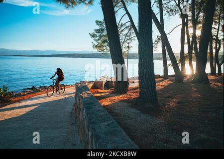 Cycliste sur la plage de Croatie, île de Murter en Dalmatie Banque D'Images