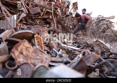 Cette photo prise sur 6 décembre 2021 montre que de la ferraille est pressée dans un chantier de démolition qui emploie des Syriens déplacés par le conflit et abrite des tonnes de véhicules collectés et d'autres restes collectés sur deux ans, dans la ville de batabo, dans le nord-ouest rural de la Syrie entre les provinces d'Idlib et d'Alep. (Photo par Muhammad al-Rifai/NurPhoto) Banque D'Images