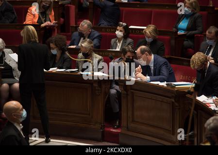 Le porte-parole du gouvernement Gabriel Attal discute avec le Premier ministre Jean Castex lors d'un discours du vice-ministre de l'économie, Agnes Pannier-Runacher (de derrière), lors de la séance de questions au gouvernement au Parlement, à Paris, le 7 décembre 2021. (Photo par Andrea Savorani Neri/NurPhoto) Banque D'Images