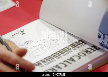 Le caricaturiste italien Michele Rech, également connu sous le nom de Zorocalcare, signe une copie d'un livre par lui à un fan, lors de la Foire nationale de l'édition petite et moyenne 'piÃ¹ Libri piÃ¹ Liberi'. 'piÃ¹ Libri piÃ¹ Liberi' est la première foire italienne entièrement dédiée à l'édition où chaque année environ 500 éditeurs, venus de toute l'Italie, présentent leurs nouvelles et leur catalogue au public. (Photo de Massimo Valicchia/NurPhoto) Banque D'Images