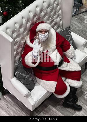 Homme habillé comme le Père Noël portant un masque pour le protéger du nouveau coronavirus (COVID-19) alors qu'il attend que les enfants posent pour une photo avec lui dans un centre commercial pendant la saison de Noël à Toronto, Ontario, Canada sur 09 décembre 2021. L'Ontario signale aujourd'hui près de 1 300 nouveaux cas de COVID-19, soit le nombre le plus élevé de cas par jour dans la province depuis plus de six mois. Les responsables de la santé provinciaux ont enregistré 1 290 nouvelles infections aujourd'hui, contre 1 009 mercredi et 959 il y a une semaine. Le total d'aujourd'hui est le nombre de cas quotidien le plus élevé signalé en Ontario depuis le 24 mai, où se sont élevées 1 446 000 infections Banque D'Images