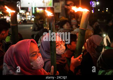 On voit un étudiant tenir une torche pendant un relais de torche comme une forme de commémoration de la Journée mondiale des droits de l'homme à Lhokseumawe, 10 décembre 2021, province d'Aceh, Indonésie. (Photo de Fachrul Reza/NurPhoto) Banque D'Images