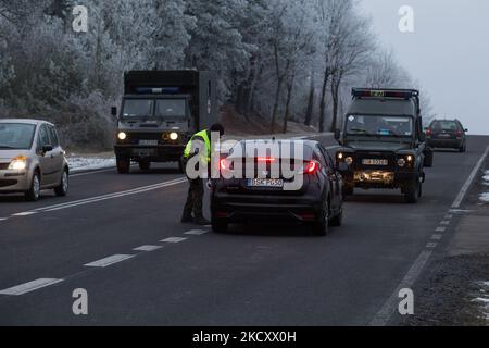 Les gardes-frontières polonais au poste de contrôle militaire vérifient les pièces d'identité des conducteurs qui souhaitent entrer dans la zone de sécurité a par la frontière biélorusse près de Kuznica, en Pologne, sur 14 décembre 2021. Le gouvernement polonais a annoncé la zone d'entrée par la frontière polonaise-Bielarus en raison d'un nombre infus d'immigrants provenant principalement du Moyen-Orient. L'armée et la police arrêtent les migrants à la frontière et les empêchent de se rendre en Pologne. L'armée est également accusée de refuser l'accès aux procédures d'asile, à l'aide médicale et à la nourriture, et de repousser le migrant vers Bielarus. La frontière entre la Biélorussie et la Pologne est également la frontière de la Th Banque D'Images