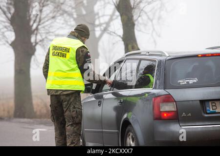 Les gardes-frontières polonais au poste de contrôle militaire vérifient les pièces d'identité des conducteurs qui souhaitent entrer dans la zone de sécurité a par la frontière biélorusse près de Kuznica, en Pologne, sur 15 décembre 2021. Le gouvernement polonais n'a pas annoncé de zone d'entrée par la frontière polonaise-Bielarus en raison d'un nombre infert d'immigrants, principalement du Moyen-Orient. La frontière entre la Biélorussie et la Pologne est également la frontière de l'Union européenne. La Pologne accuse le régime Loukachenko d’orchestrer le transit de milliers de migrants du Moyen-Orient pour faire pression sur l’UE. En raison de la crise, l'UE a proposé de nouvelles lois sur les frontières qui mettent en péril l'absence d'itd Banque D'Images