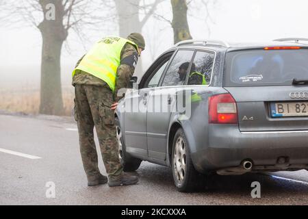 Les gardes-frontières polonais au poste de contrôle militaire vérifient les pièces d'identité des conducteurs qui souhaitent entrer dans la zone de sécurité a par la frontière biélorusse près de Kuznica, en Pologne, sur 15 décembre 2021. Le gouvernement polonais n'a pas annoncé de zone d'entrée par la frontière polonaise-Bielarus en raison d'un nombre infert d'immigrants, principalement du Moyen-Orient. La frontière entre la Biélorussie et la Pologne est également la frontière de l'Union européenne. La Pologne accuse le régime Loukachenko d’orchestrer le transit de milliers de migrants du Moyen-Orient pour faire pression sur l’UE. En raison de la crise, l'UE a proposé de nouvelles lois sur les frontières qui mettent en péril l'absence d'itd Banque D'Images