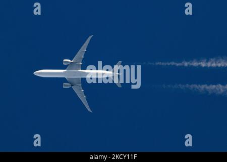 Un avion blanc volant à 40,000 pieds dans le ciel bleu pendant une journée ensoleillée au-dessus de l'Europe, un vol pendant une journée d'hiver claire. L'illustration du symbole de l'avion à grand-corps survolant sans logo imprimé sur le dessous du ventre du fuselage laisse derrière lui des contrailles ou un sentier de condensation, une ligne de vapeur blanche. L'industrie de l'aviation et le trafic de passagers sont en phase de phase avec une période difficile avec la pandémie du coronavirus Covid-19 ayant un impact négatif sur l'industrie du voyage d'affaires avec la crainte d'une aggravation de la situation en raison de la nouvelle mutation de la variante Omega. Eindhoven, pays-Bas sur D. Banque D'Images