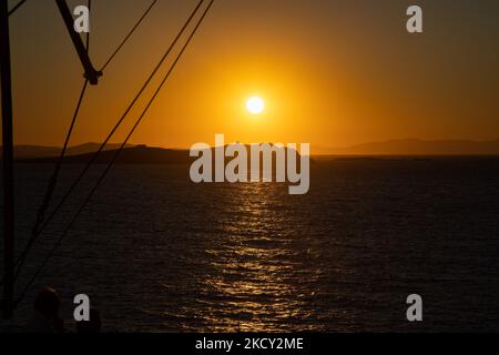 Silhouette d'une petite église au sommet de la colline au-dessus de la mer pendant le coucher du soleil. Les touristes apprécient un beau coucher de soleil pendant l'heure magique à l'île de Mykonos en Grèce. L'île grecque de Myconos est une destination prisée de voyage en Méditerranée pour des vacances dans les Cyclades, la mer Égée avec les bâtiments emblématiques blanchis à la chaux, les plages de sable et la célèbre fête aux bars de plage. L'industrie du tourisme et du voyage a eu un impact négatif dans le secteur des affaires et de l'économie locale en raison de la pandémie du coronavirus Covid-19. Île de Mykonos, Grèce sur 10 octobre 2021 (photo de Nicolas Economou/NurPh Banque D'Images