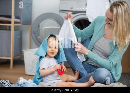 bonne jeune mère souriante avec un petit bébé à la maison Banque D'Images