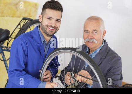 vélo stagiaire mécanicien et maître travaillant sur vtt Banque D'Images