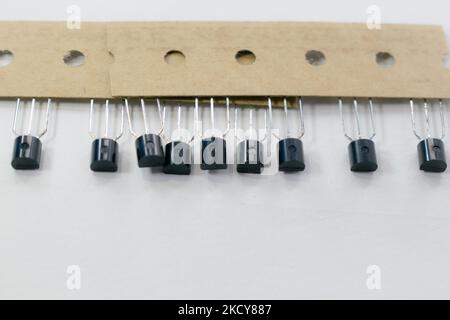 rangée de transistors électroniques isolés sur fond blanc avec espace de copie. Banque D'Images