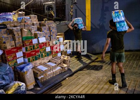 Des membres de la Marine philippine chargent des marchandises pour les opérations de secours à bord du BRP Tarlac (LD601) amarré au port de Manille, sur 21 décembre 2021. Les données publiées par la police nationale philippine (PNP) ont révélé un nombre de morts de 375 56 personnes, et autres ont été portées disparues après que le Super typhon Rai a dévasté les provinces du sud du pays en 16 décembre dernier, entraînant une destruction généralisée et une pénurie massive de nourriture et d'eau. (Photo de George Calvelo/NurPhoto) Banque D'Images