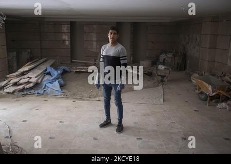 Fereydoun Ahmadi-26, réfugié afghan et champion du monde de kickboxing, qui doit travailler comme ouvrier de la construction pour collecter de l'argent pour les dépenses de subsistance, porter des gants de protection pose pour une photo dans un bâtiment résidentiel en construction, Dans la région de Mehrshahr à l'ouest de la ville de Karaj dans la province d'Alborz 53km (33 milles) nord-ouest de Téhéran sur 10 octobre 2021. Fereydoun est champion du monde de kickboxing et sa femme Masoumeh est également instructeur de kickboxing, qui sont tous deux afghans et sont nés en Iran, souhaitant un jour qu'ils puissent vivre en paix dans un pays Banque D'Images