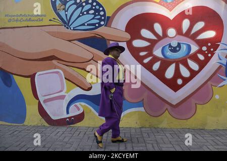 Pablo Estevez, pachuco, prend sa retraite et marche en face d'une fresque en face de la Plaza de la Ciudadela près du Centro Histórico de Mexico, où la musique comme mambo, danzón, salsa et jazz est dansée pendant l'urgence sanitaire COVID-19 et le feu vert de circulation épidémiologique dans la ville. C'est un style d'être et de s'habiller qui a émergé dans les 1930s jeunes dans la zone frontalière du Mexique et des États-Unis. Le costume de zoot de Baggy est apparu dans le 1930s à Harlem, New York, parmi les musiciens de jazz et a été appelé draperies. Par la suite, son utilisation s'est répandue parmi les communautés non anglo-saxonnes de ce type Banque D'Images