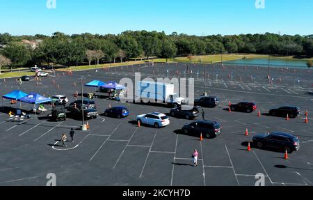 29 décembre 2021- Lac Mary, Floride, États-Unis - dans cette vue aérienne d'un drone, les gens font la queue dans des voitures pour recevoir gratuitement à la maison des kits d'essai COVID-19 sur un site de passage à Seminole State College sur 29 décembre 2021 à Lake Mary, Floride. Les 10 800 kits de test rapide ont été distribués en deux heures pour répondre à la demande croissante de tests car le taux d'infection augmente en raison de la variante Omicron. (Photo de Paul Hennessy/NurPhoto) Banque D'Images