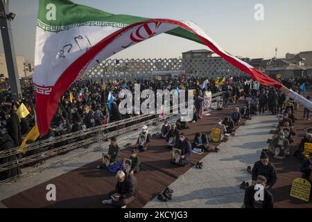 Les hommes iraniens ont des portraits du Guide suprême iranien, l’ayatollah Ali Khamenei, tout en assistant à un rassemblement sur la place Imam Hussein, dans le sud-est de Téhéran, à 30 décembre 2021. Les partisans du Guide suprême de l'Iran, l'ayatollah Ali Khamenei, assistent à un rassemblement pour marquer l'anniversaire des manifestations anti-opposition du 2009 décembre à Téhéran. (Photo de Morteza Nikoubazl/NurPhoto) Banque D'Images