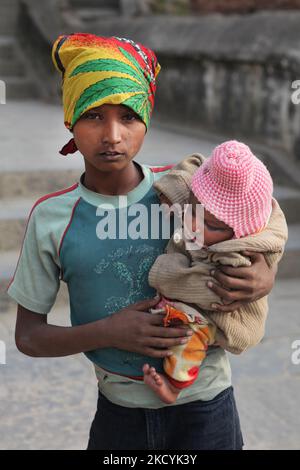 Garçon tient sa petite sœur alors qu'il menche dans les rues de Katmandou City, au Népal. La pauvreté et le travail des enfants sont deux problèmes importants auxquels le Népal est confronté. (Photo de Creative Touch Imaging Ltd./NurPhoto) Banque D'Images