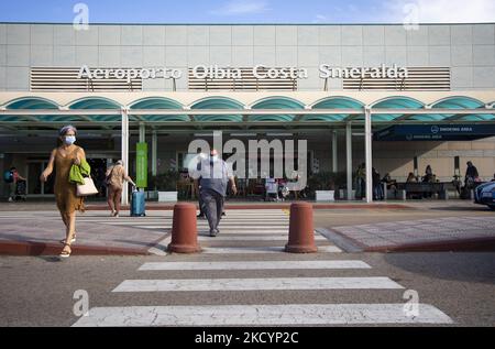 Les voyageurs portant des masques de protection contre Covid-19 et transportant des bagages marchent devant l'entrée de l'aéroport Olbia Costa Smeralda en Sardaigne, Italie sur 1 septembre 2021. (Photo par Emmanuele Contini/NurPhoto) Banque D'Images