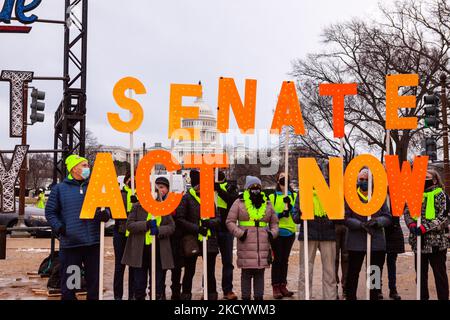 Les bénévoles affichent des panneaux exhortant le Sénat à protéger le droit de vote lors d'une veillée aux chandelles en souvenir de l'insurrection de 6 janvier. Cet événement est l'un des nombreux événements organisés à l'échelle nationale par 6 janvier Vigils for Democracy. L'organisation et ses partenaires demandent au Congrès d'adopter la loi John Lewis sur l'avancement des droits de vote, la loi sur la liberté de vote, la loi sur la protection de notre démocratie et la loi sur la création d'un État. (Photo d'Allison Bailey/NurPhoto) Banque D'Images