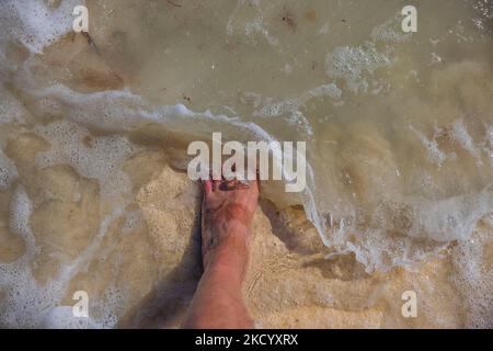 Vue rapprochée de la jambe mâle sur la mer de l'océan Atlantique pendant la vague. Concept de vacances d'été. Aruba Banque D'Images