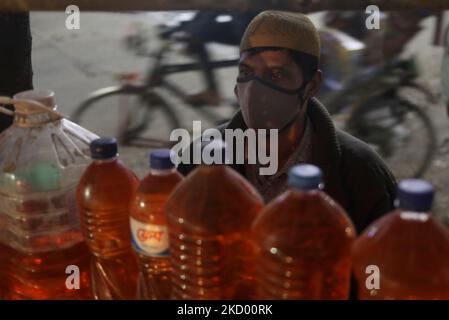 Un vendeur attend des clients en dehors d'une autoroute alors qu'il vend de l'essence en bouteille plastique à Dhaka, au Bangladesh, sur 08 janvier 2021. (Photo de Syed Mahamudur Rahman/NurPhoto) Banque D'Images