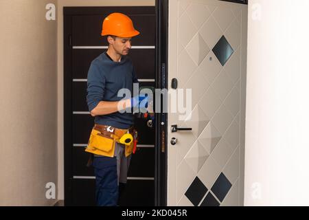 Perçage et installation des portes intérieures, l'artisan fait un trou dans le cadre de porte avec un foret à main, des portes et l'installation Banque D'Images