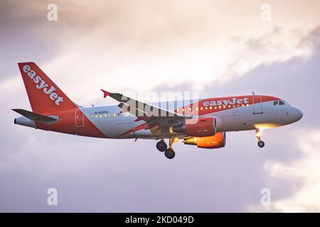 EasyJet Airbus A319 tel que vu lors de l'approche finale vol et atterrissage à l'aéroport d'Amsterdam Schiphol AMS EHAM avec la tour de contrôle et le terminal de l'aéroport en arrière-plan dans la soirée. L'avion arrivant de la compagnie aérienne multinationale britannique à bas prix a l'enregistrement G-EZFU. L'industrie de l'aviation et le trafic de passagers est en phase de phase difficile avec la pandémie du coronavirus Covid-19 ayant un impact négatif sur l'industrie du voyage d'affaires avec crainte de l'aggravation de la situation en raison de la nouvelle mutation de la variante Omega. Amsterdam, pays-Bas sur 5 janvier 2022 (photo de Nicol Banque D'Images