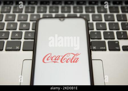 Dans cette illustration photo, un logo Coca-Cola apparaît sur l'écran d'un smartphone avec un mot-clé d'ordinateur en arrière-plan à Athènes, Grèce sur 13 janvier 2022. (Photo de Nikolas Kokovovlis/NurPhoto) Banque D'Images