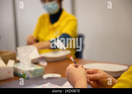 Gros plan sur la seringue, le flacon et les mains d'une femme préparant le coup de rappel. Le professionnel de la santé publique de GGD prépare les vaccins Moderna Spikemax mRNA Covid-19 en les tirant du flacon en verre à des doses individuelles dans les seringues dans la zone spéciale du méga centre de vaccination d'Eindhoven. Les injections sont administrées comme une injection de rappel. La troisième dose de rappel est disponible pour tous aux pays-Bas en plus du confinement alors que la nation combat les épidémies de la nouvelle mutation du coronavirus de la variante omicron de la pandémie. Eindhoven, pays-Bas sur 7 janvier 2022 (photo par N Banque D'Images