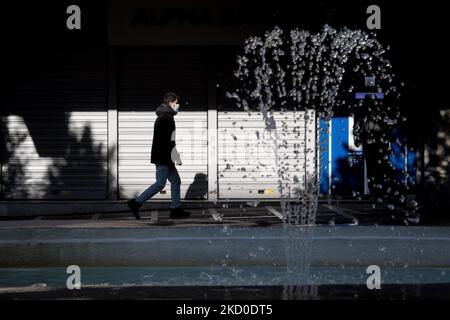 Un homme portant un masque protégé passe près d'une fontaine au centre d'Athènes, en Grèce, sur 15 janvier 2022. (Photo de Nikolas Kokovovlis/NurPhoto) Banque D'Images