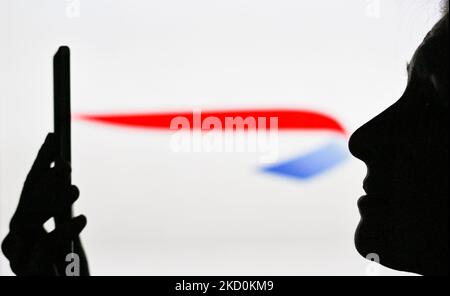 Image d'une femme tenant un téléphone portable devant le logo British Airways affiché sur un écran d'ordinateur. Mardi, 12 janvier 2021, à Edmonton, en Alberta, Canada. (Photo par Artur Widak/NurPhoto) Banque D'Images