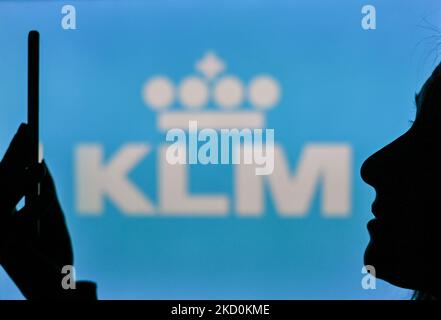 Image d'une femme tenant un téléphone portable devant le logo KLM affiché sur un écran d'ordinateur. Mardi, 12 janvier 2021, à Edmonton, en Alberta, Canada. (Photo par Artur Widak/NurPhoto) Banque D'Images