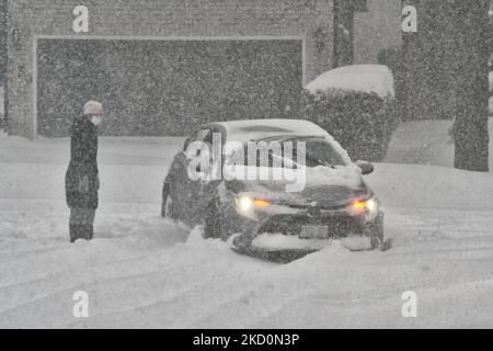 Une femme figure comment libérer une voiture après qu'elle a été enlisée dans la neige sur une route alors qu'une tempête de neige massive a frappé Toronto, Ontario, Canada, sur 17 janvier 2022. Selon Environnement Canada, la tempête couvrait la ville en chutes de neige de 30 à 45 centimètres (un mois de neige tombant en une seule journée). À Toronto, la neige a causé la fermeture de routes et d'écoles dans toute la ville, y compris deux autoroutes principales. Quelques 50-60 cm de neige sont tombés lundi dans certaines régions, ce qui a incité les météorologues à dire que la tempête était un événement d'une fois sur dix, en particulier son ampleur. (Photo par C Banque D'Images