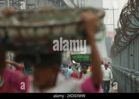 Les laboureurs marchent le long du pont howrah dans la matinée Foggy sur le fleuve Ganga dans le cadre de l'urgence du coronavirus sur 21 janvier 2022 à Kolkata, Bengale occidental, Inde. (Photo de Debajyoti Chakraborty/NurPhoto) Banque D'Images