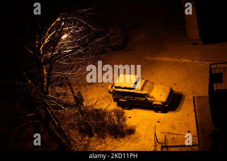 Un feu de rue illumine la voiture et la rue couverte de neige à Cracovie, en Pologne, sur 22 janvier 2022. (Photo de Jakub Porzycki/NurPhoto) Banque D'Images