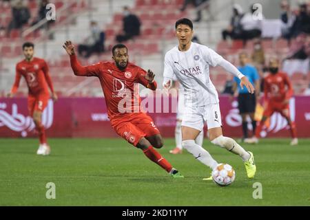 Jung Woo-Young (5) d'Al Sadd passe le ballon alors que Ahmed Fatehi (8) d'Al Arabi ferme pendant la Ligue des étoiles QNB entre Al Sadd et Al Arabi au stade Grand Hamad à Doha, Qatar, le 22 janvier 2022. (Photo de Simon Holmes/NurPhoto) Banque D'Images