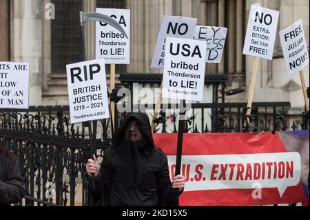 LONDRES, ROYAUME-UNI - le 24 JANVIER 2022 : un partisan de Julian Assange détient des pancartes devant les cours royales de justice le jour de la décision sur l'autorisation ou non à Julian Assange de faire appel de la décision d'extradition des États-Unis devant la Cour suprême de 24 janvier 2022, à Londres, en Angleterre. Assange, le fondateur de WikiLeaks, a été inculpé de 17 chefs d'accusation en vertu de la loi américaine sur l'espionnage de 1917 pour avoir sollicité, recueilli et publié des documents militaires américains secrets et est condamné à une peine de 175 ans de prison s'il est extradé et reconnu coupable. (Photo de Wiktor Szymanowicz/NurPhoto) Banque D'Images