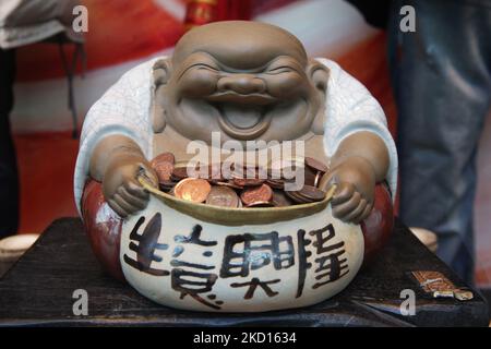 Le Bouddha riant tient un petit bol avec le changement offert par les dévoués pendant la nouvelle année lunaire chinoise du serpent à Markham, Ontario, Canada. (Photo de Creative Touch Imaging Ltd./NurPhoto) Banque D'Images