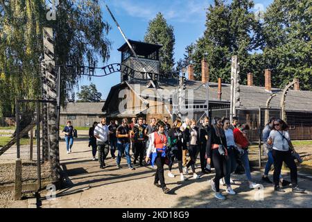 Les visiteurs traversent la porte d'entrée avec l'inscription « Arbeit Macht Frei » dans l'ancien camp de concentration allemand nazi d'Auschwitz I au site du Mémorial d'Auschwitz. Oswiecim, Pologne sur 4 octobre 2021. (Photo de Beata Zawrzel/NurPhoto) Banque D'Images