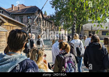 Les visiteurs traversent la porte d'entrée avec l'inscription « Arbeit Macht Frei » dans l'ancien camp de concentration allemand nazi d'Auschwitz I au site du Mémorial d'Auschwitz. Oswiecim, Pologne sur 4 octobre 2021. (Photo de Beata Zawrzel/NurPhoto) Banque D'Images