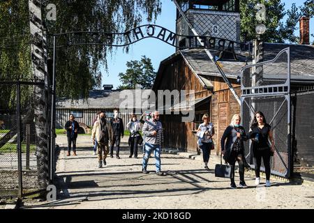 Les visiteurs traversent la porte d'entrée avec l'inscription « Arbeit Macht Frei » dans l'ancien camp de concentration allemand nazi d'Auschwitz I au site du Mémorial d'Auschwitz. Oswiecim, Pologne sur 4 octobre 2021. (Photo de Beata Zawrzel/NurPhoto) Banque D'Images