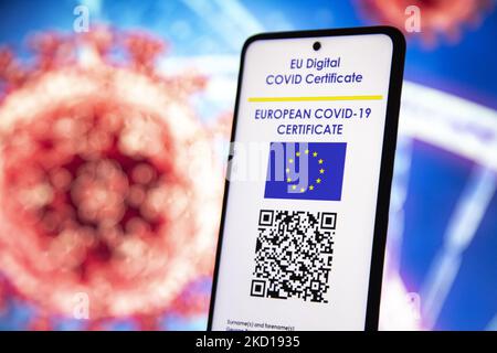 Illustration photo d'une main tenant et montrant l'affichage d'un téléphone portable avec un certificat de vaccination numérique européen Covid-19 avec un QR, un certificat de vaccination international ou un passe sanitaire avec une illustration du virus Covid et un ADN / ARN sur le fond. Photo sur le sujet des faux certificats de vaccination. Actuellement, la propagation de la pandémie se fait sur la cinquième vague du coronavirus, la mutation omicron étant la variante dominante. Amsterdam, pays-Bas sur 25 janvier 2022 (photo de Nicolas Economou/NurPhoto) Banque D'Images