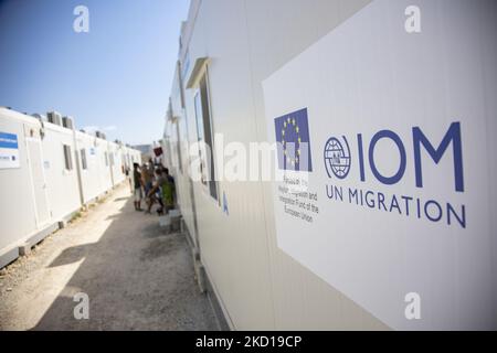 Un panneau portant le logo DE MIGRATION de l'OIM à l'ONU. Dans le nouveau camp de réfugiés de l'île de Samos qui a été créé en Grèce avec le soutien de l'UE, puisqu'il s'agit de la première installation contrôlée fermée financée par l'UE, le nouveau RIC de Samos (centre d'accueil et d'identification) Comme l'Europe va dépenser 276 millions d'euros d'argent de l'UE pour de nouveaux camps sur les îles de Samos, Lesbos, Chios, Kos et Leros . La vie quotidienne dans le nouveau camp de migrants avec les maisons préfabriquées, une installation contrôlée fermée où les gens peuvent entrer seulement en utilisant leur carte en plus de leur empreinte biométrique. Le nouveau camp peut accueillir jusqu'à 3500 personnes Banque D'Images