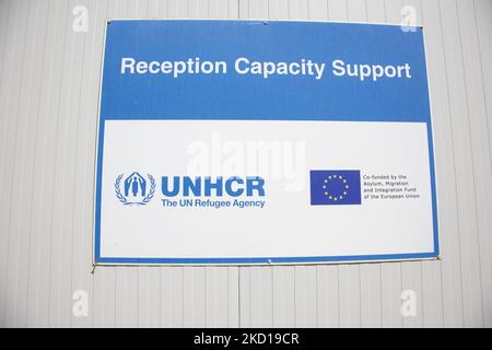 Un panneau avec le logo du HCR et le drapeau européen. Dans le nouveau camp de réfugiés de l'île de Samos qui a été créé en Grèce avec le soutien de l'UE, puisqu'il s'agit de la première installation contrôlée fermée financée par l'UE, le nouveau RIC de Samos (centre d'accueil et d'identification) Comme l'Europe va dépenser 276 millions d'euros d'argent de l'UE pour de nouveaux camps sur les îles de Samos, Lesbos, Chios, Kos et Leros . La vie quotidienne dans le nouveau camp de migrants avec les maisons préfabriquées, une installation contrôlée fermée où les gens peuvent entrer seulement en utilisant leur carte en plus de leur empreinte biométrique. Le nouveau camp peut accueillir t Banque D'Images
