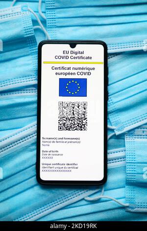 Le certificat COVID numérique de l'UE est affiché sur un écran de téléphone mobile photographié sur un masque chirurgical pour une photo d'illustration pendant la propagation de la cinquième vague de la pandémie du coronavirus. Cracovie, Pologne sur 26 janvier 2022. (Photo de Beata Zawrzel/NurPhoto) Banque D'Images