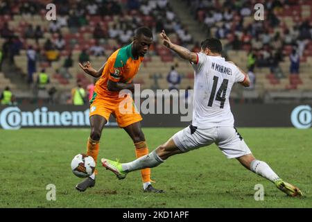(19) l'équipe de Nicolas Pépé de Côte d'Ivoire a lutté pour le bal avec (14) Mostafa Mohamed d'Egypte pendant la coupe d'Afrique des Nations Cameron 2021 ronde de 16 match de football entre la Côte d'Ivoire et l'Egypte au Stade de Japoma à Douala sur 26 janvier 2022. (Photo par Ayman Aref/NurPhoto) Banque D'Images
