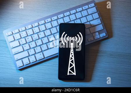 Illustration photo d'un logo de symbole de signal 5G affiché sur l'écran d'un smartphone au-dessus d'un clavier. Eindhoven, pays-Bas sur 27 janvier 2022 (photo Illustration de Nicolas Economou/NurPhoto) Banque D'Images