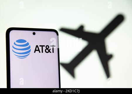 Illustration photo d'AT&T affichée sur l'écran d'un téléphone portable avec une illustration du symbole d'avion sur l'arrière-plan montrant les voyages et l'aviation. AT&T Inc. L'American Telephone and Telegraph Company est une société de portefeuille multinationale américaine enregistrée au Delaware. AT&T est la plus grande société de télécommunications au monde et le plus grand fournisseur de services de téléphonie mobile aux États-Unis. Eindhoven, pays-Bas sur 27 janvier 2022 (photo Illustration de Nicolas Economou/NurPhoto) Banque D'Images