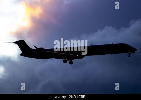 Silhouette, photo de symbole, illustration d'un avion volant dans l'air contre les nuages colorés. SAS Scandinavian Airlines Bombardier Mitsubishi CRJ-900 tel qu'il a été vu voler sur l'approche finale pour l'atterrissage à l'aéroport d'Amsterdam Schiphol AMS EHAM dans une soirée nuageux. L'avion régional à corps étroit a l'enregistrement EI-FPV et le nom Trud Viking. SAS est le porte-drapeau du Danemark, de la Norvège et de la Suède. Le nom est une abréviation de Scandinavian Airlines System. La compagnie aérienne compte 180 appareils et est membre du groupe d'aviation Star Alliance. L'industrie de l'aviation et le trafic de passagers sont Banque D'Images